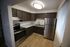 Modern kitchen with stainless steel appliances, elegant dark wood cabinets, and stylish granite countertops, perfect for culinary enthusiasts.