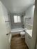Bright and modern bathroom featuring elegant tile design and spacious bathtub, ideal for relaxation.