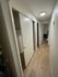 Inviting hallway with sleek wooden flooring leading to multiple rooms in a cozy apartment setting.