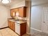 Inviting kitchen featuring warm wooden cabinets, modern fixtures, and a sleek dual sink with a bright atmosphere.