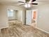Bright and spacious bedroom featuring plush carpet, a mirrored closet, and modern ceiling fan beside an ensuite bathroom.