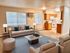 Inviting open-concept living room with cozy seating, natural light, and an adjacent modern kitchen.