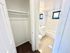 Bright bathroom with modern fixtures, a bathtub, and adjacent cozy closet space, designed for comfortable living.