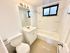 Bright and modern bathroom featuring a sleek white vanity, elegant bathtub, and ample natural light through the stylish window.