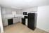 Modern kitchen with sleek black appliances, elegant gray cabinets, and a stylish marble countertop.