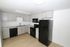 Modern kitchen with sleek black appliances, elegant gray cabinetry, and sophisticated marble countertops, ideal for culinary creativity.