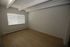 Bright, spacious room with large window and elegant wooden flooring, perfect for a cozy living space.