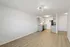 Modern open-concept kitchen and living area with sleek cabinetry, stainless steel appliances, and elegant flooring.