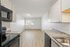 Modern kitchen with sleek appliances and ample natural light, featuring stylish countertops and a spacious layout.
