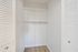 Bright, spacious walk-in closet with modern shelving and sleek hardwood flooring.