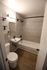 Modern bathroom with sleek fixtures, elegant tile work, and rich wood flooring, offering a stylish and functional space.