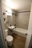 Modern bathroom with sleek tiles, elegant fixtures, and stylish wood flooring.