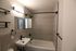 Modern bathroom with sleek fixtures, elegant lighting, and chic tile design creating a soothing atmosphere.