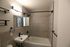 Modern bathroom with elegant gray tiles, a sleek bathtub, and contemporary black fixtures.