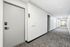 Modern apartment hallway with stylish gray doors, sleek keypad entry, and clean carpeting.