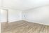 Spacious interior with elegant wood flooring and fresh white walls, perfect for personalization and modern living.