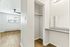 Bright and airy apartment corner featuring an elegant closet space with shelving, sleek vanity area, and a modern ceiling fan above exquisite wood flooring.