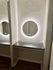 Elegant vanity area with a sleek, illuminated circular mirror and granite countertop, adding a touch of luxury to the space.