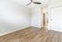 Bright and airy bedroom with sleek wood flooring, ceiling fan, and spacious closet for modern living.