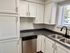 Chic kitchen with sleek stainless steel appliances, elegant white cabinets, and a modern double sink with a polished countertop.