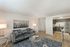 Contemporary living room with elegant decor, plush gray sofa, stylish glass coffee table, and open kitchen area with modern appliances.