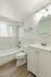 Bright, modern bathroom with elegant marble tiles, stylish vanity, and inviting bathtub, enhanced by natural light.