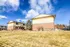 Charming two-story brick and siding apartment complex with a spacious lawn under a bright blue sky.