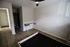 Bright and inviting bedroom with sleek wood flooring, a modern desk, and ample closet space, perfect for a functional and stylish living space.