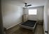 Inviting bedroom with modern ceiling fan, hardwood floors, and ample natural light, perfect for relaxation.