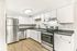 Modern kitchen with sleek stainless steel appliances, elegant white cabinetry, and beautiful wood flooring.
