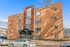 Charming brick apartment building with contemporary design, featuring large windows and ample parking in a vibrant neighborhood.