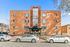 Charming brick apartment building with modern windows and inviting entrance, located at 2444 S. York, with convenient parking and clear blue sky backdrop.