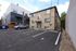Charming apartment exterior with modern design, ample parking, and a serene urban setting.