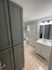 Modern bathroom interior with sleek gray cabinetry, elegant lighting, and a pristine white sink.
