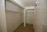 Spacious walk-in closet with ample hanging space and elegant lighting.