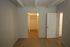 Elegant room with a spacious walk-in closet and cozy wooden flooring, illuminated by soft lighting.
