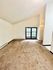 Bright and spacious living room with plush carpet and French doors leading to a serene outdoor view.