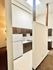 Charming kitchen with rustic wood cabinetry, high ceilings, and modern lighting in an inviting apartment space.