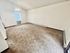 Bright, spacious room with plush carpeting, high ceiling, and a large window inviting natural light.