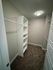 Spacious walk-in closet with modern shelving and stylish lighting, offering ample storage.
