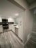 Modern kitchen with sleek stainless steel appliances, elegant white cabinetry, and stylish wood flooring.