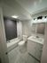 Modern bathroom showcasing elegant marble flooring, sleek vanity, and contemporary lighting.
