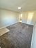 Bright and inviting room with fresh carpet, neutral toned walls, and a modern light fixture, perfect for a cozy living space.