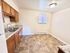 Bright, modern kitchen with sleek countertops, dual sink, and elegant wood cabinets; perfect for culinary creativity.