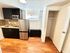 Contemporary kitchen with sleek stainless steel appliances, modern cabinetry, and elegant wood flooring, perfect for stylish urban living.