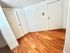 Elegant entryway with polished hardwood floors and modern white doors, offering a warm and inviting atmosphere.