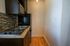 Compact modern kitchen with sleek dark cabinetry, stainless steel appliances, and stylish tile backsplash.