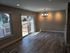 Bright dining area with elegant chandelier, sliding glass doors, and modern wood flooring, offering a seamless indoor-outdoor experience.