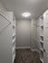 Spacious walk-in closet with ample shelving and modern lighting, perfect for organized living.