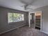 Bright and airy room with large windows, plush carpet, and a spacious closet, perfect for a cozy retreat.